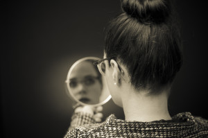 this woman is reflecting on herself by looking in the mirror