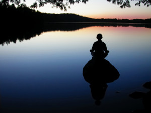 woman meditating on rock